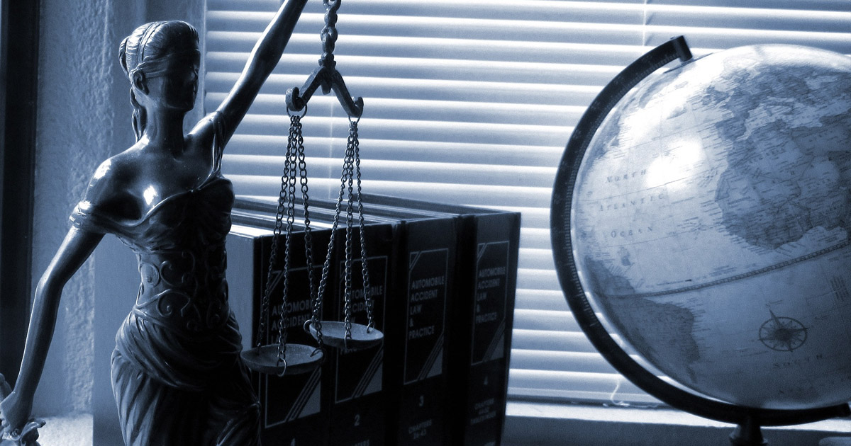 Lady Justice statue with scales and world globe, symbolizing international law and legal system