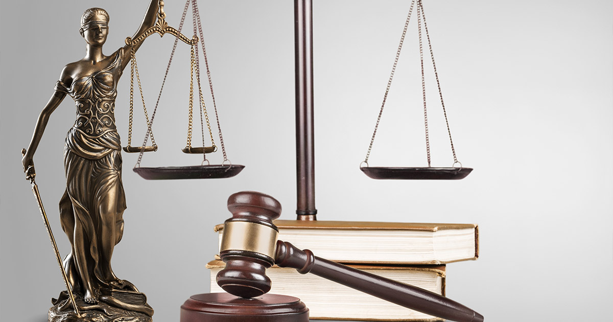 Lady Justice statue with scales and wooden gavel on law books, symbolizing legal system and judicial process